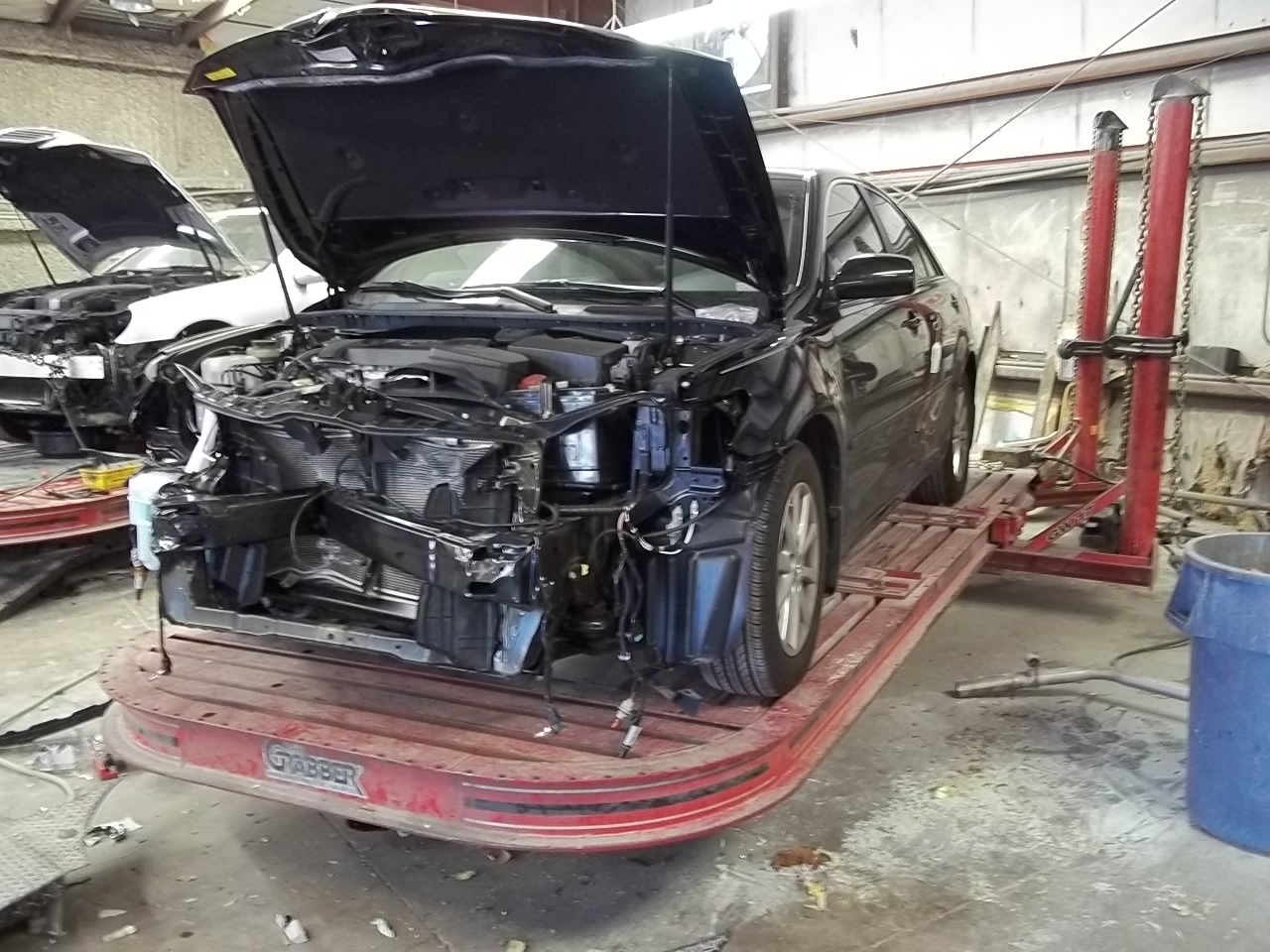 a car with a damaged frame on 25-ton pulling capacity frame bench